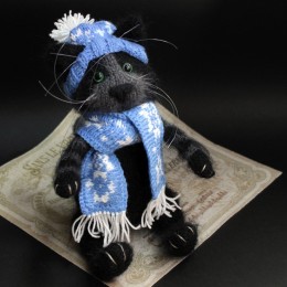 Фото Игрушка вязаная Чёрный кот в синем шарфе и шапке